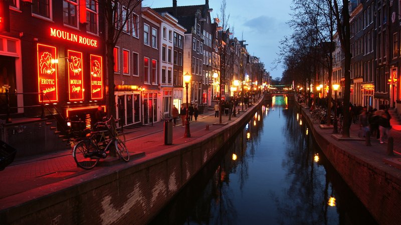 Dzielnica czerwonych latarni w Amsterdamie podczas wieczornego widoku na kanał