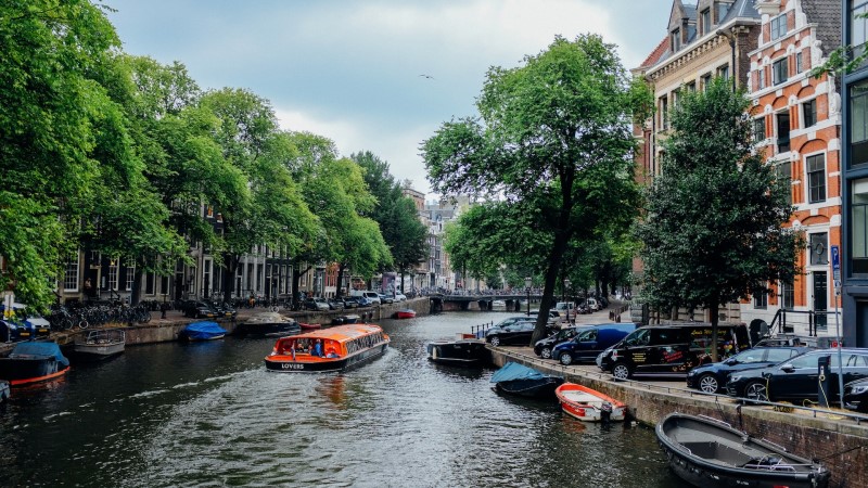 Rejs po kanałach Amsterdamu w ciągu dnia między zabytkowymi budynkami